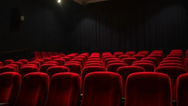 Rows of empty red seats in a cinema auditorium
